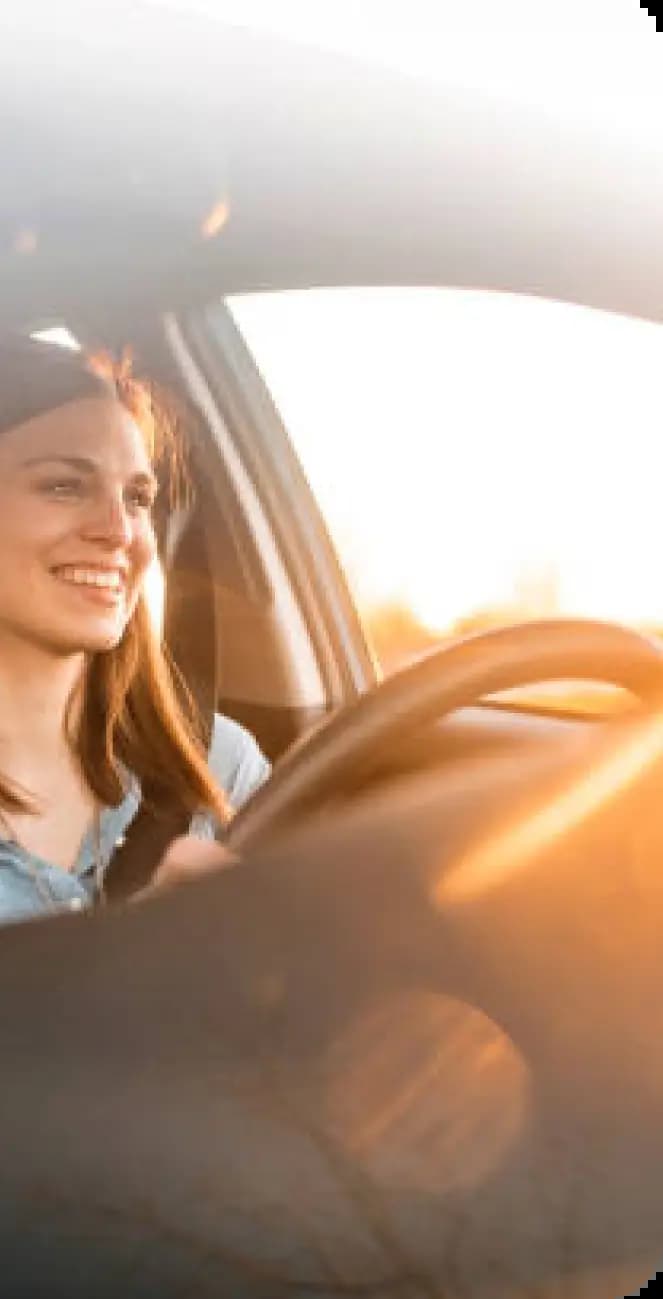 Person driving car during golden hour with natural warm lighting