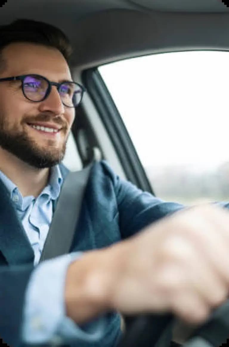 Person wearing glasses driving car in professional attire