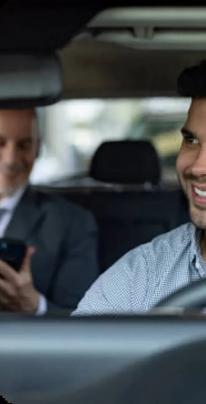 Person holding phone while seated in car